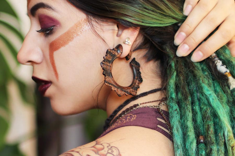woman wearing ear hangers, wooden hoops for stretched ears