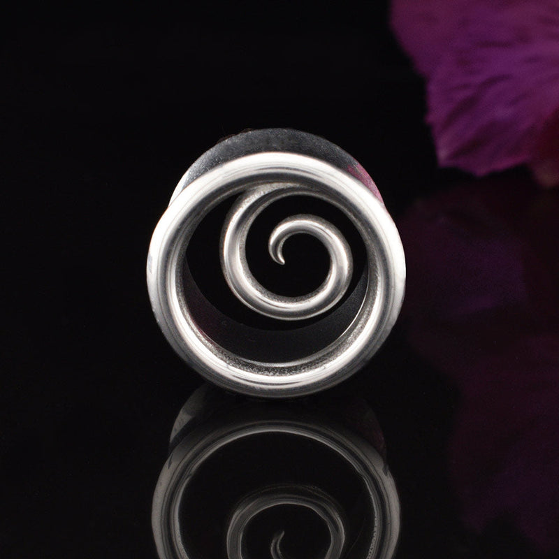 a steel ear tunnel with a spiral design on a black background