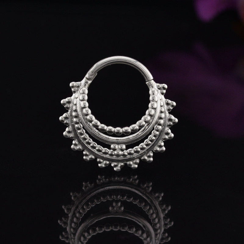 Indian style hinged segment clicker ring onblack background