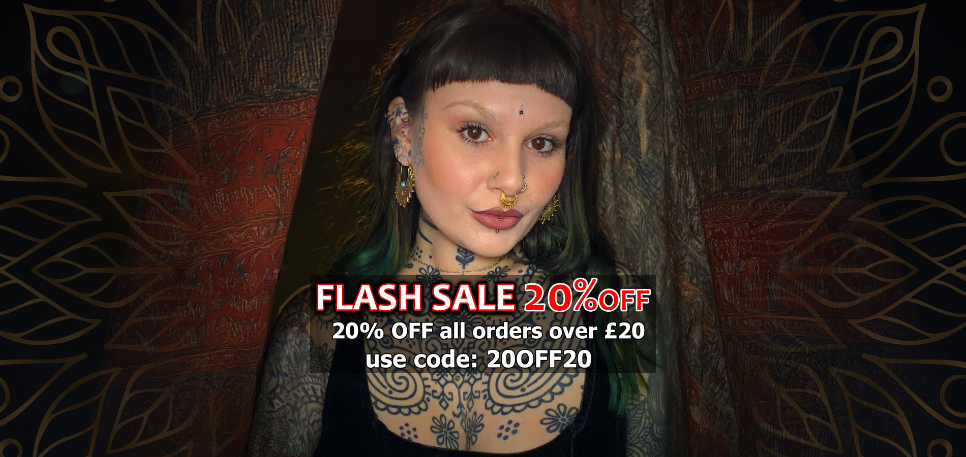 alternative woman with tattoos and piercings wearing a septum ring, nose studs and tribal earrings standing in front of indian drapes with a flash sale promotion