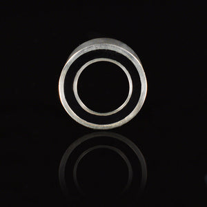 double flared ear tunnels, silver brass with a black rim