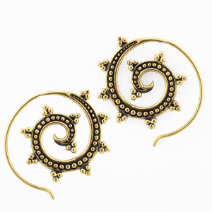 Gold brass spiral earrings on a white background