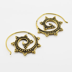 Pair of gold spiral indian earrings on a white background