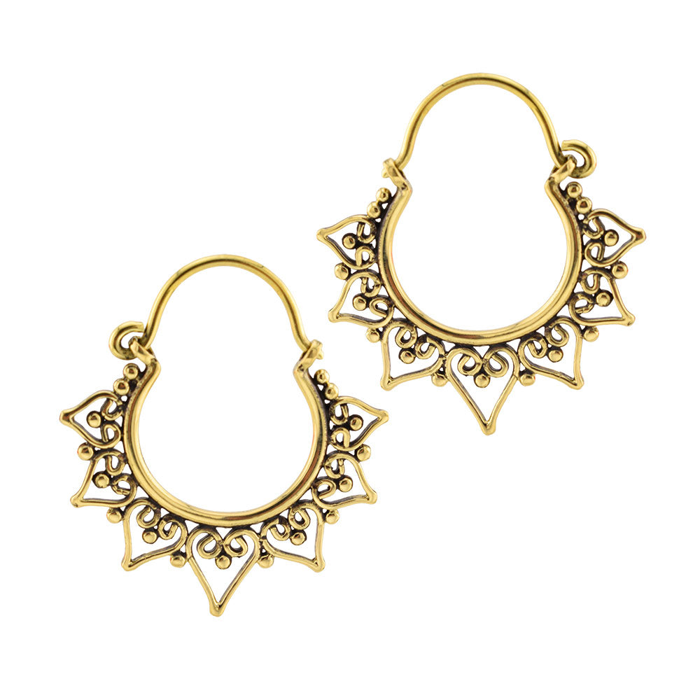 A pair of golden brass heart filigree hoop earrings with ornate openwork detailing and a scalloped triangular heart design, shown on a plain white background.