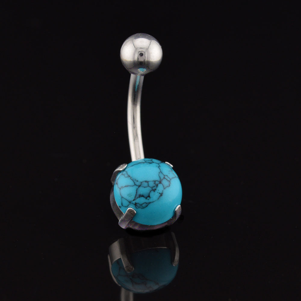 Belly button ring with turquoise stone on a black background