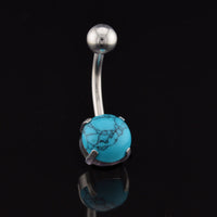 Belly button ring with turquoise stone on a black background