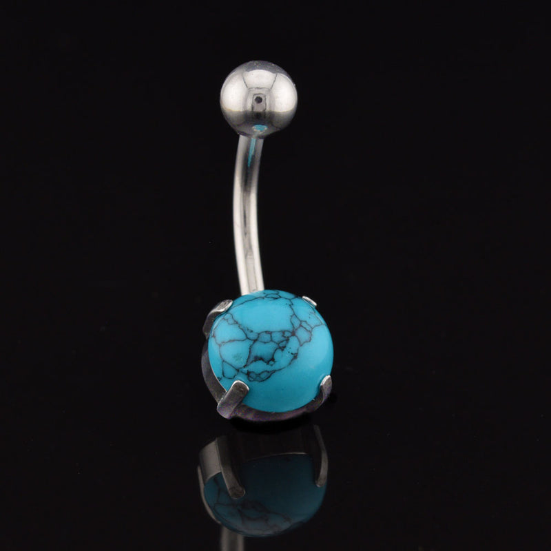 Belly button ring with turquoise stone on a black background