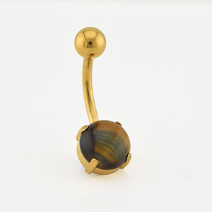 Gold belly button ring with a tiger's eye stone on a white background