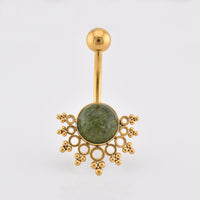 Tribal Navel Bar, Gold-plated navel jewelry featuring a round green afircan jade stone centerpiece surrounded by decorative gold filigree, on a plain light gray background.