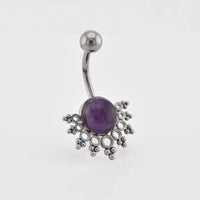 A tribal navel bar/ curved barbell belly button ring featuring a central purple amethyst gemstone surrounded by a decorative snowflake-like cluster of small silver beads and loops, shown on a plain light gray background.