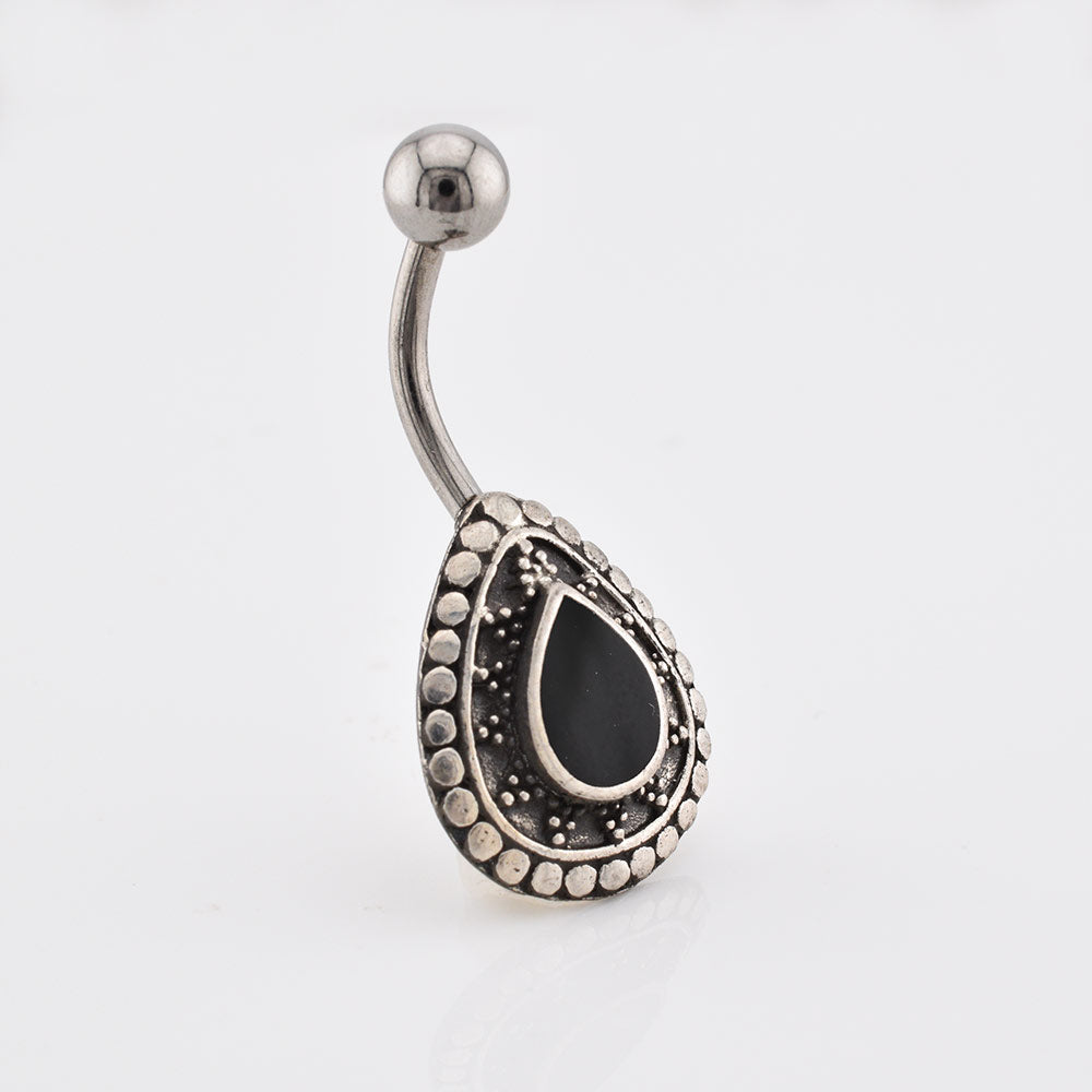 A silver ended curved barbell belly button ring with a teardrop-shaped shield featuring a black teardrop center and a border of small silver dots, shown on a plain white background.