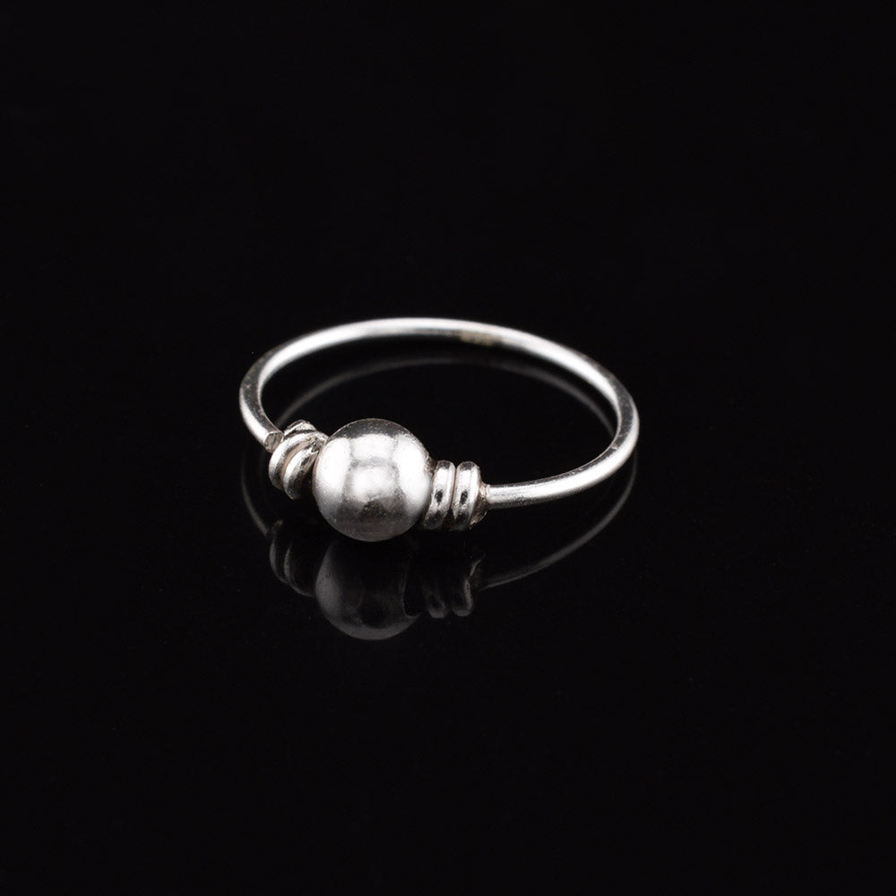 silver nose ring with small ball on black background