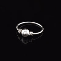 silver nose ring with small ball on black background