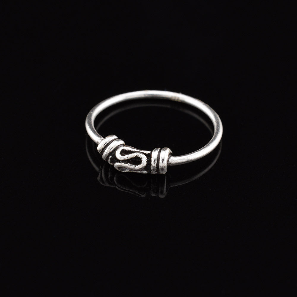 silver nose ring with traditional bali design on ablack background
