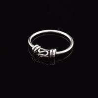 silver nose ring with traditional bali design on ablack background