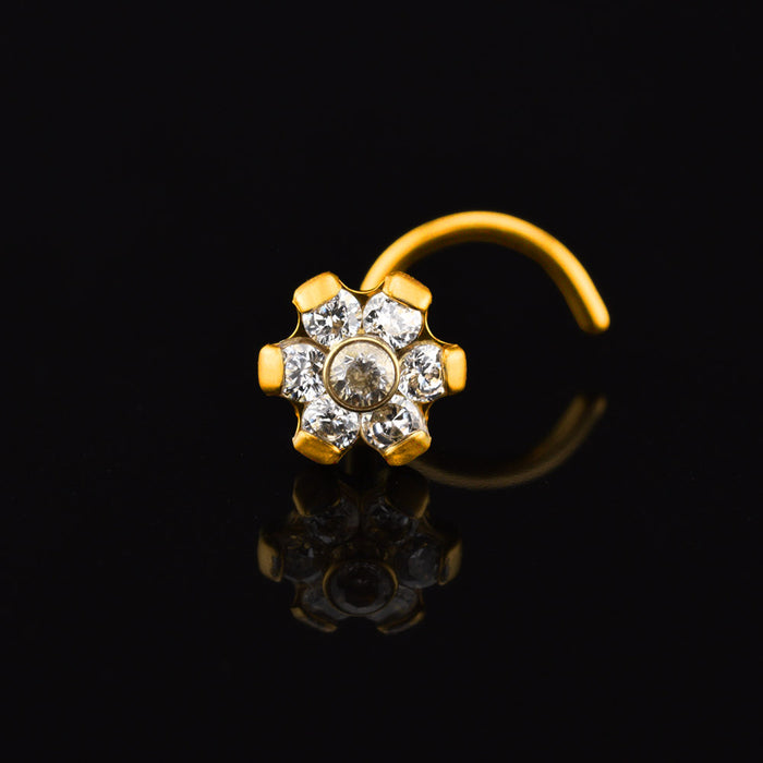 gold titanium nose stud with crystal flower design on a black background