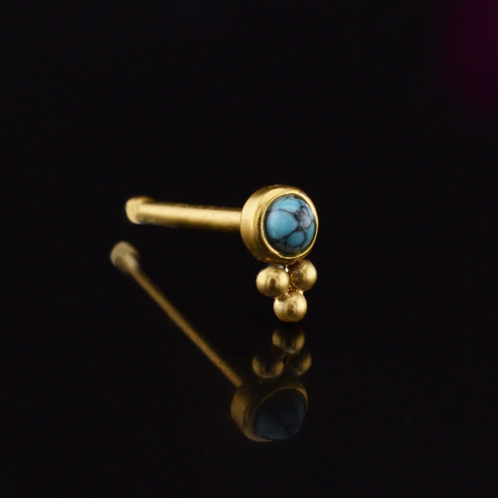 gold coloured nose stud with tribal beads and a turquoise stone on a black background