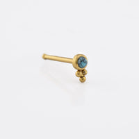 gold coloured nose stud with tribal beads and a turquoise stone on a white background