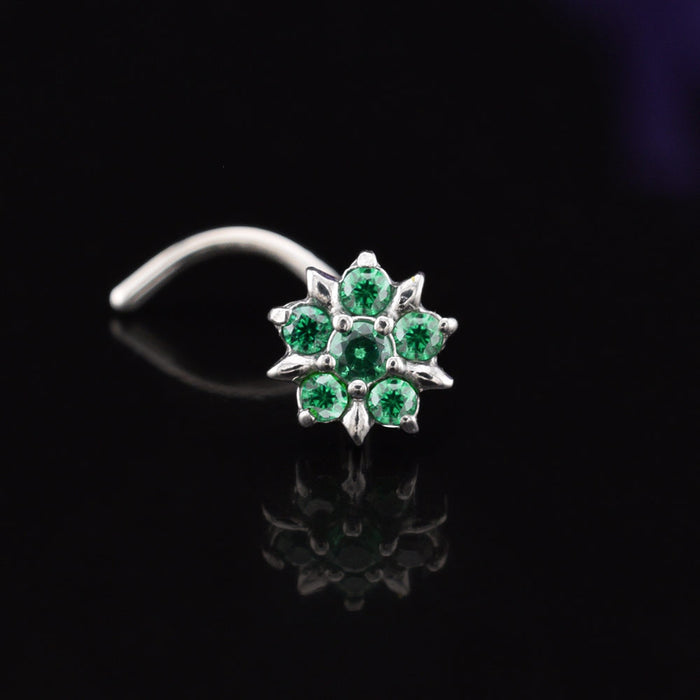 Nose screw wirh emerald green cubic zirconia stones set in a flower design on a black background