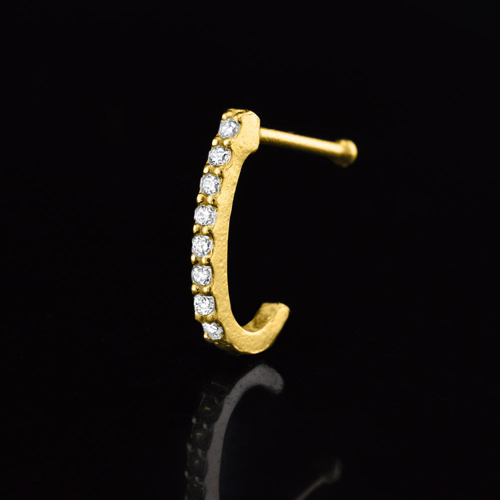 gold nose curve with cz crystal gems on a black reflective background