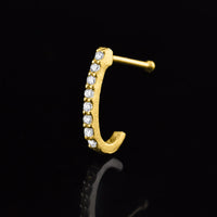 gold nose curve with cz crystal gems on a black reflective background