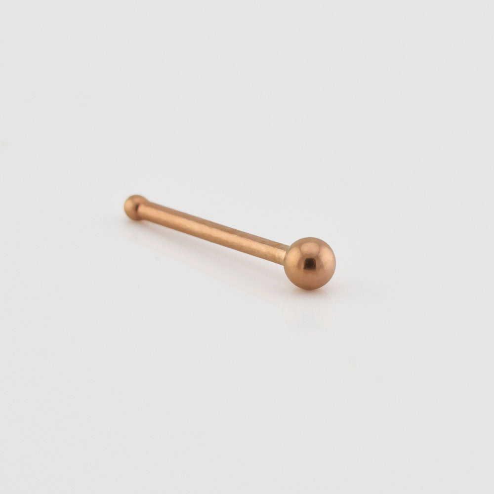 Rose gold nose pin on a light gray background