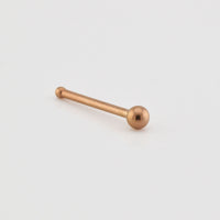 Rose gold nose pin on a light gray background