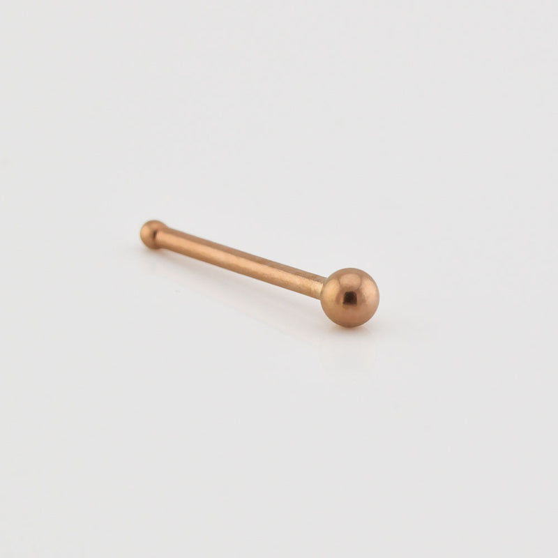 Rose gold nose pin on a light gray background