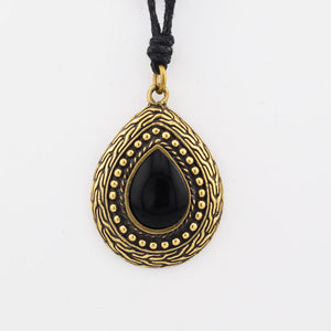 Black teardrop pendant with gold detailing on a white background