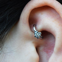 close up of a rook clicker in a rook piercing in an ear