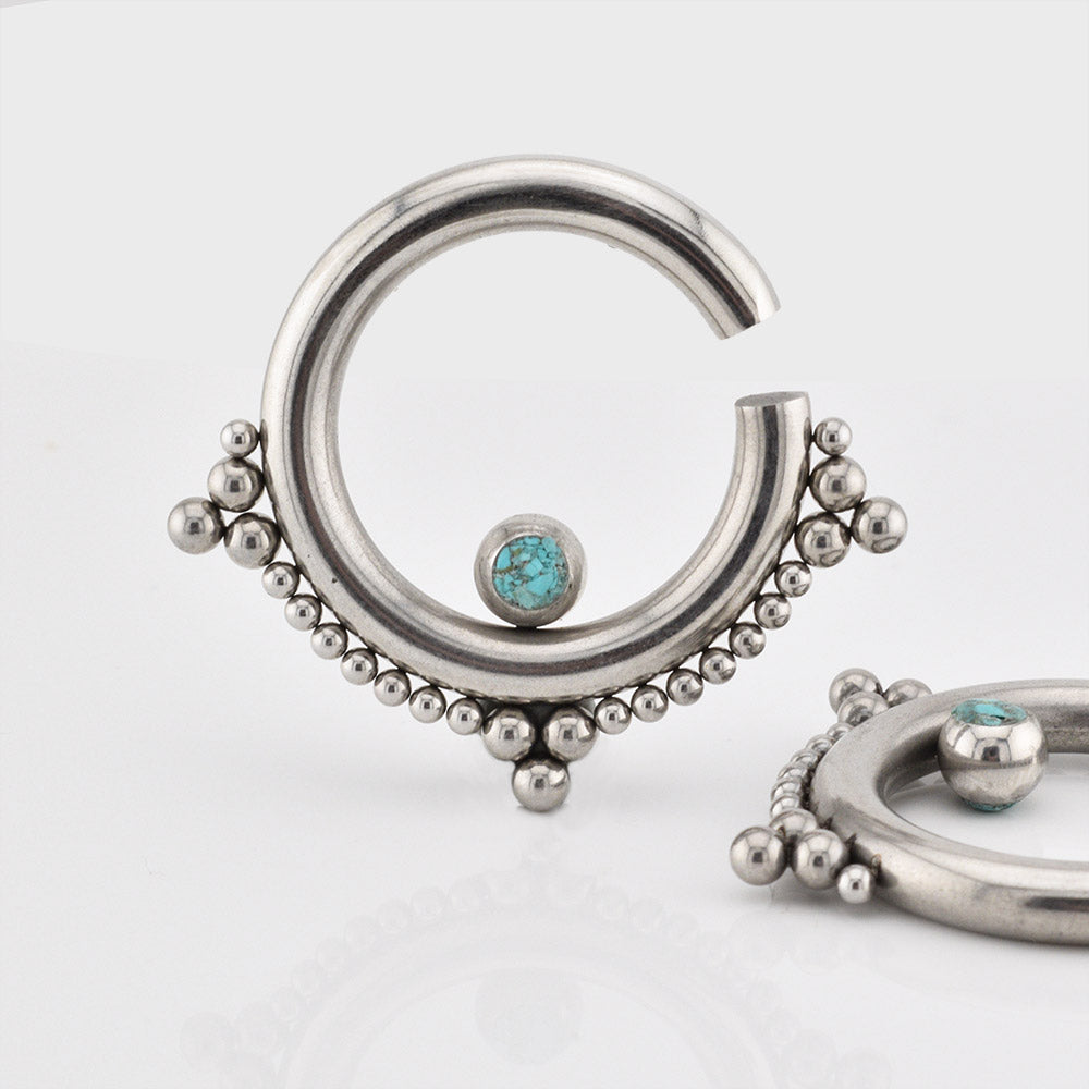 Ear hangers in steel with tribal beading and turquoise stone on a white background