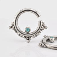 Ear hangers in steel with tribal beading and turquoise stone on a white background
