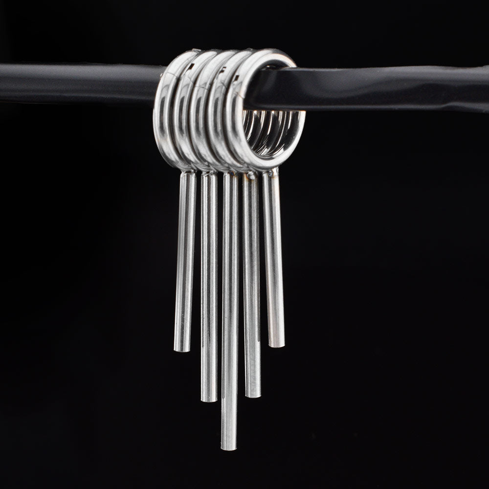 clicker ring stack with drop spikes for stretched ears in surgical steel on a black background