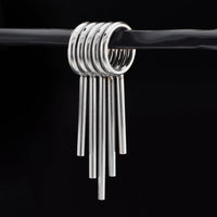 clicker ring stack with drop spikes for stretched ears in surgical steel on a black background