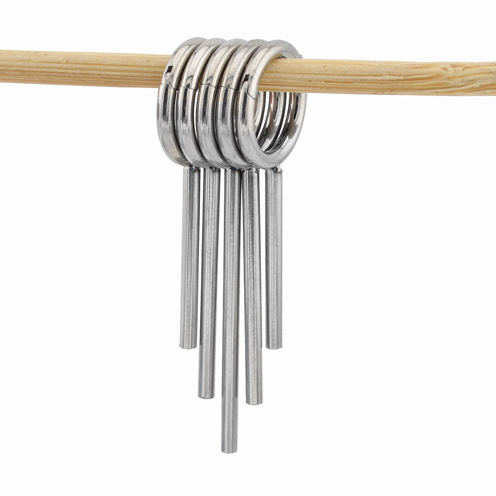 clicker ring stack with drop spikes for stretched ears in surgical steel hanging on a wooden dowel against a white background
