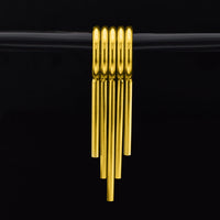 Stack of 5 gold coloured clicker rings with drop spikes for wearing in stretched ears on a black background 