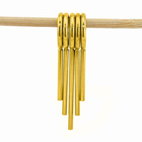 Stack of 5 gold coloured clicker rings with drop spikes for wearing in stretched ears on a white background