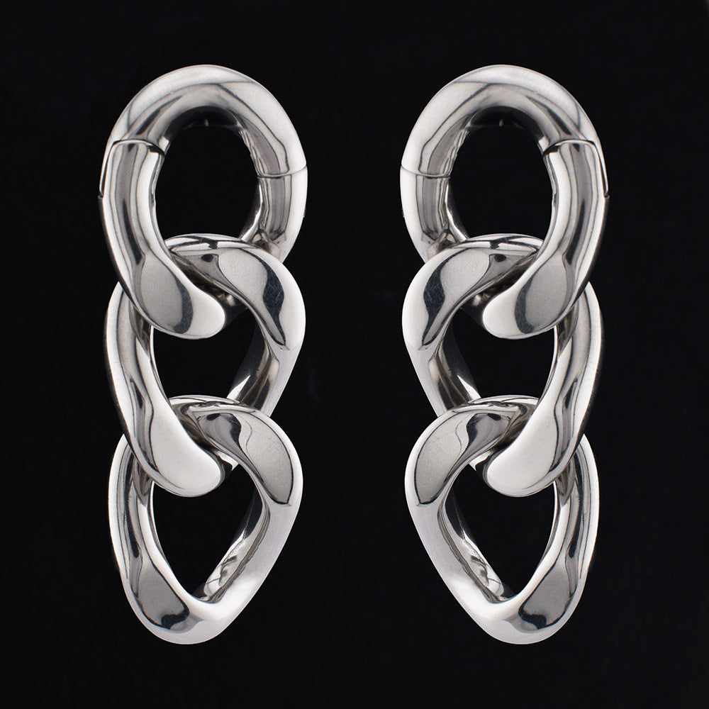 curb chain ear weights in steel on a black background