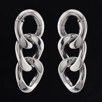 curb chain ear weights in steel on a black background