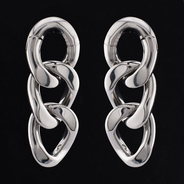 curb chain ear weights in steel on a black background