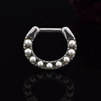 Silver steel septum clicker ring with pearls on a black background