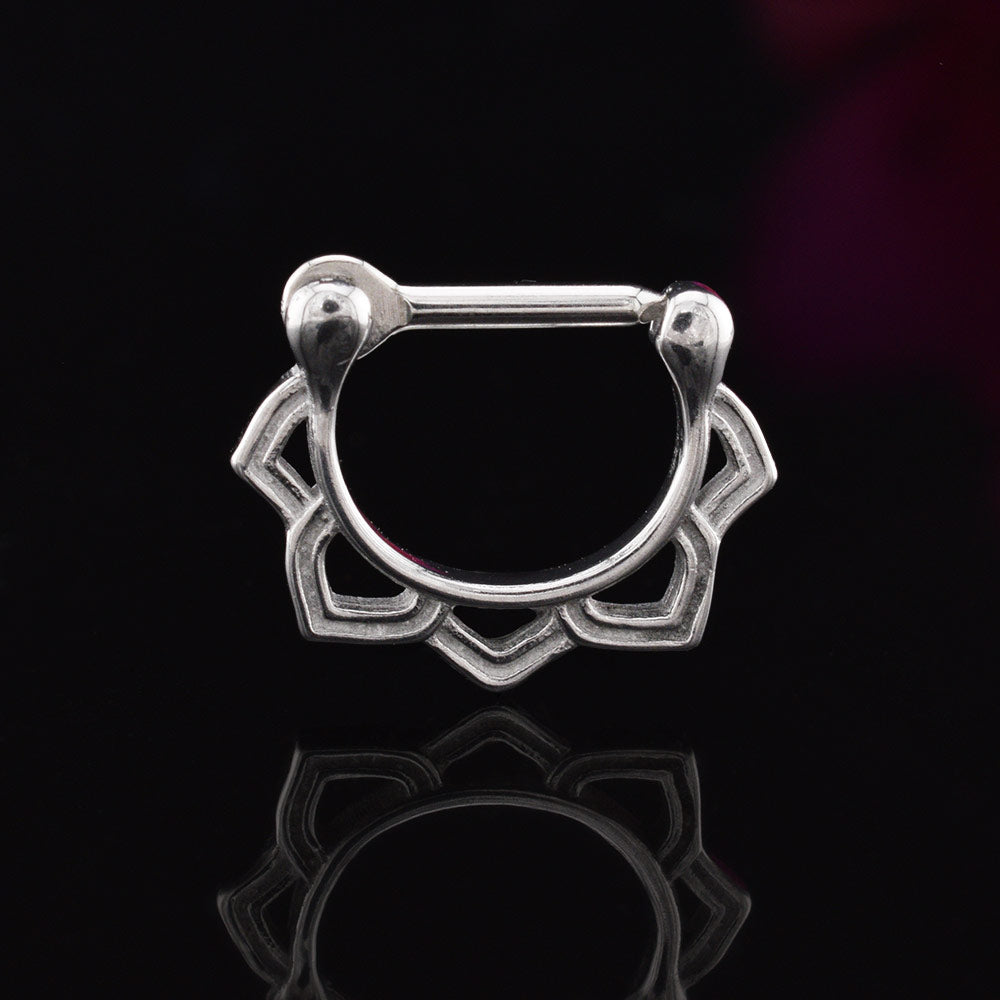 septum clicker ring with lotus petals design on a black reflective background