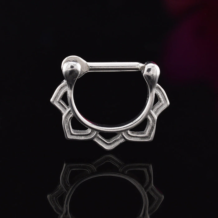 septum clicker ring with lotus petals design on a black reflective background