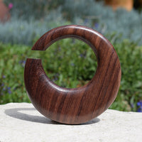 wooden ear hanger hoop on a white wall in a garden