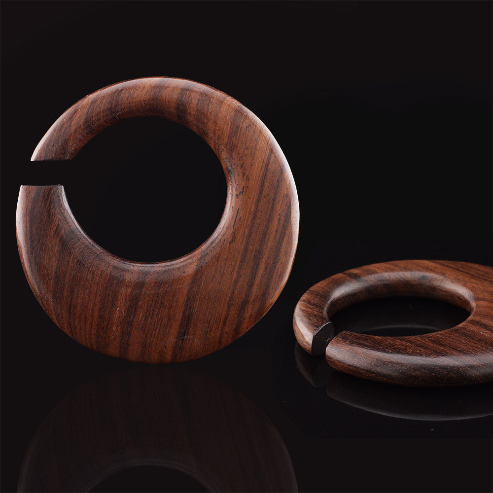 ear hangers in wood on a black surface