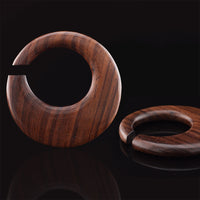 ear hangers in wood on a black surface
