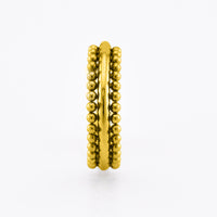 A gold  steel beaded hinged segment ring with two parallel bands, each featuring a row of small metallic beads, shown on a clean white background.