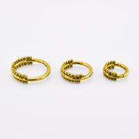 Three gold-colored beaded hoop earrings in different sizes, arranged horizontally on a clean white background.