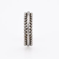 A surgical steel triple-band hinged segment clicker ring featuring one smooth band and two beaded bands, displayed on a plain white background