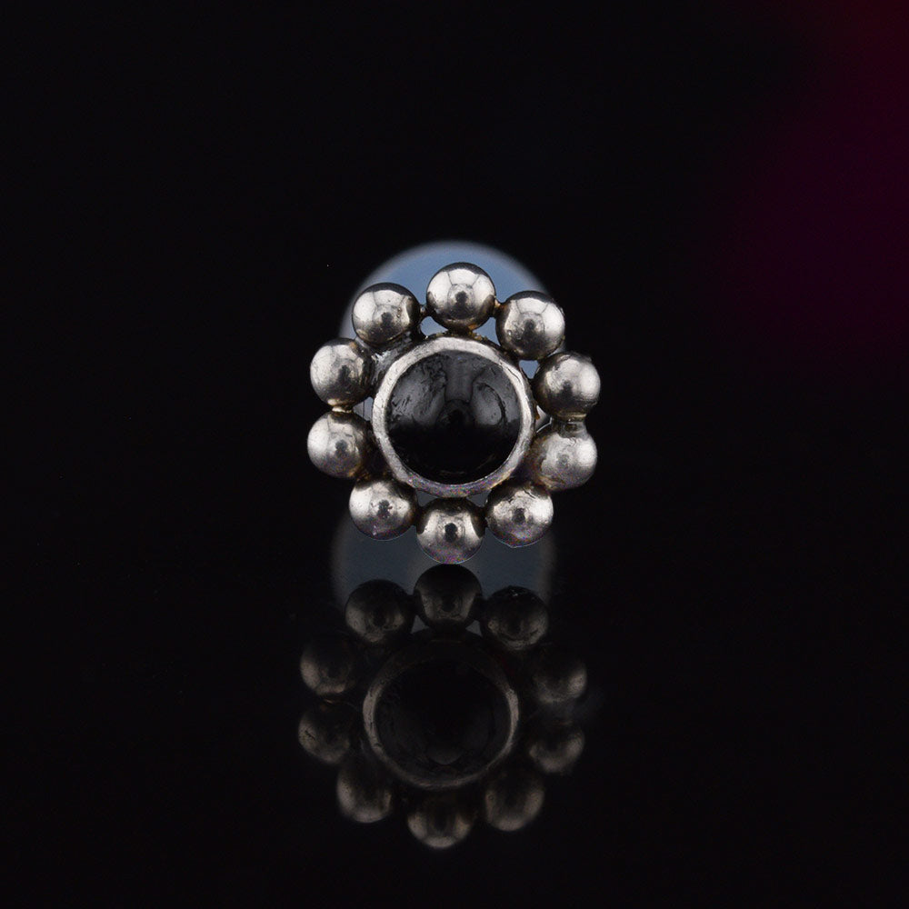 Bioflex PTFE labret with a black onyx stone surrounded by tribal beading on a black background